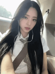 a girl with long black hair wearing headphones and a tie