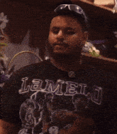 a man wearing sunglasses and a black lamelo shirt