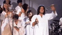 a man singing into a microphone in front of a group of people