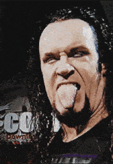 a man sticking his tongue out in front of a sign that says ' go down '