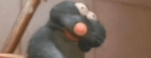 a close up of a cartoon rat with big eyes and a red nose .