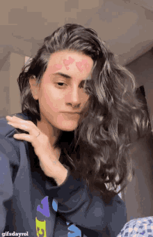 a woman with hearts on her face is wearing a gifsdayrol hoodie