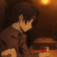 a man in a suit and tie is sitting at a table with a glass of red liquid