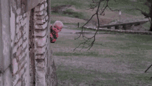 a baby is peeking out of a window with pink smoke coming out of it