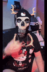 a person wearing a skull mask and a hello kitty t-shirt