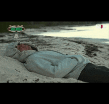 a man laying on a beach with a sign that says villanos in the background