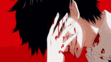 a person with blood on their face is covering their face with their hands .