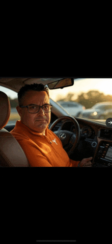a man wearing glasses is sitting in a car