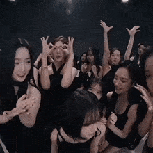 a group of young women in black dresses are making funny faces .