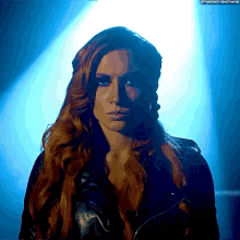 a woman with long red hair wearing a leather jacket