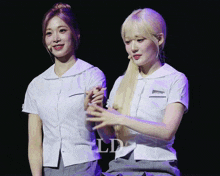 two girls are standing next to each other with the letters ld on the bottom right