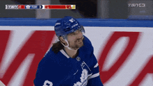 a hockey player wearing a number 8 jersey stands on the ice