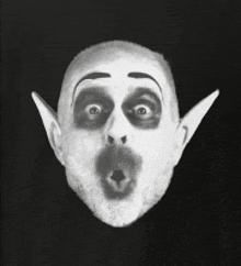 a close up of a man 's face with a surprised look on his face