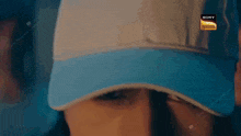 a close up of a person wearing a blue and white hat .