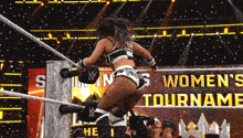 a woman in a wrestling ring with the words women 's tournament on the screen
