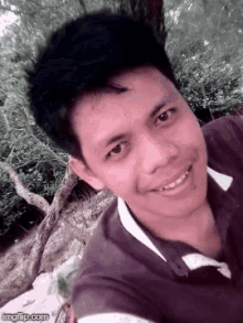 a young man is smiling for the camera while taking a selfie .