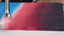 a brush is being used to paint a picture on a canvas