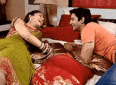 a man and woman are laying on a bed laughing