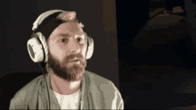 a man with a beard is wearing headphones and a hat