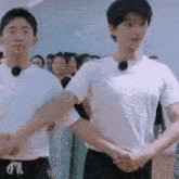 two men are shaking hands in front of a group of people in a room .