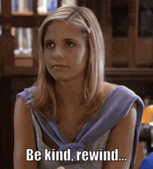 a woman is sitting at a table and says be kind rewind .