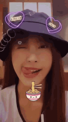 a woman wearing a bucket hat with xoxo hearts on it