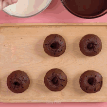 a wooden cutting board with three chocolate cupcakes on it and the word easy on the bottom