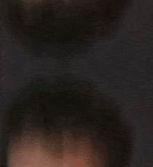 a woman in a blue shirt has her hand on her chin