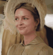 a woman wearing a hat with feathers on it is smiling