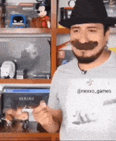 a man wearing a cowboy hat and a fake mustache is giving a thumbs up