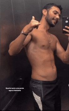 a shirtless man is taking a selfie in an elevator with the caption queria tanto uma praia agora hahaha