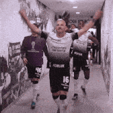 a group of soccer players are walking down a hallway wearing jerseys that say foxlux