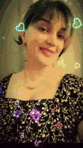 a woman wearing a necklace and a black and white dress smiles