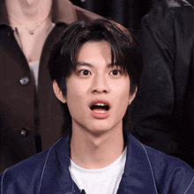 a young man with a surprised look on his face .