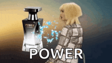 a woman stands in front of a perfume bottle that says power