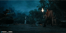 a man is holding a torch in front of a wolf and the words pranay varma are on the bottom right
