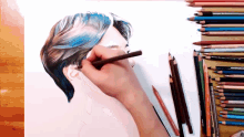 a person is drawing a person 's head with colored pencils including prismacolor