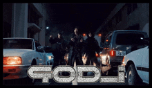a group of people standing on a street with god written in rhinestones