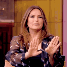 a woman in a striped shirt is clapping her hands together