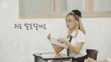 a girl in a school uniform is sitting at a desk in a classroom .