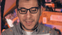 a man with glasses and a beard is looking at something