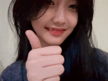 a woman giving a thumbs up with her tongue out