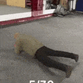 an older man is doing push ups on the floor in a gym .