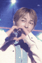 a close up of a person making a heart with their hands