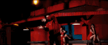 a man in a red shirt is dancing in a room