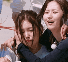 two women are hugging each other and one of them is smiling
