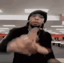 a man in a black hat is giving a middle finger in a store .