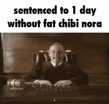 a judge is sitting at a desk in a courtroom with a hammer .