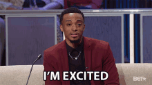 a man sitting on a couch with the words i 'm excited written on his face