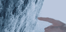a person 's finger is pointing at a wall of snow